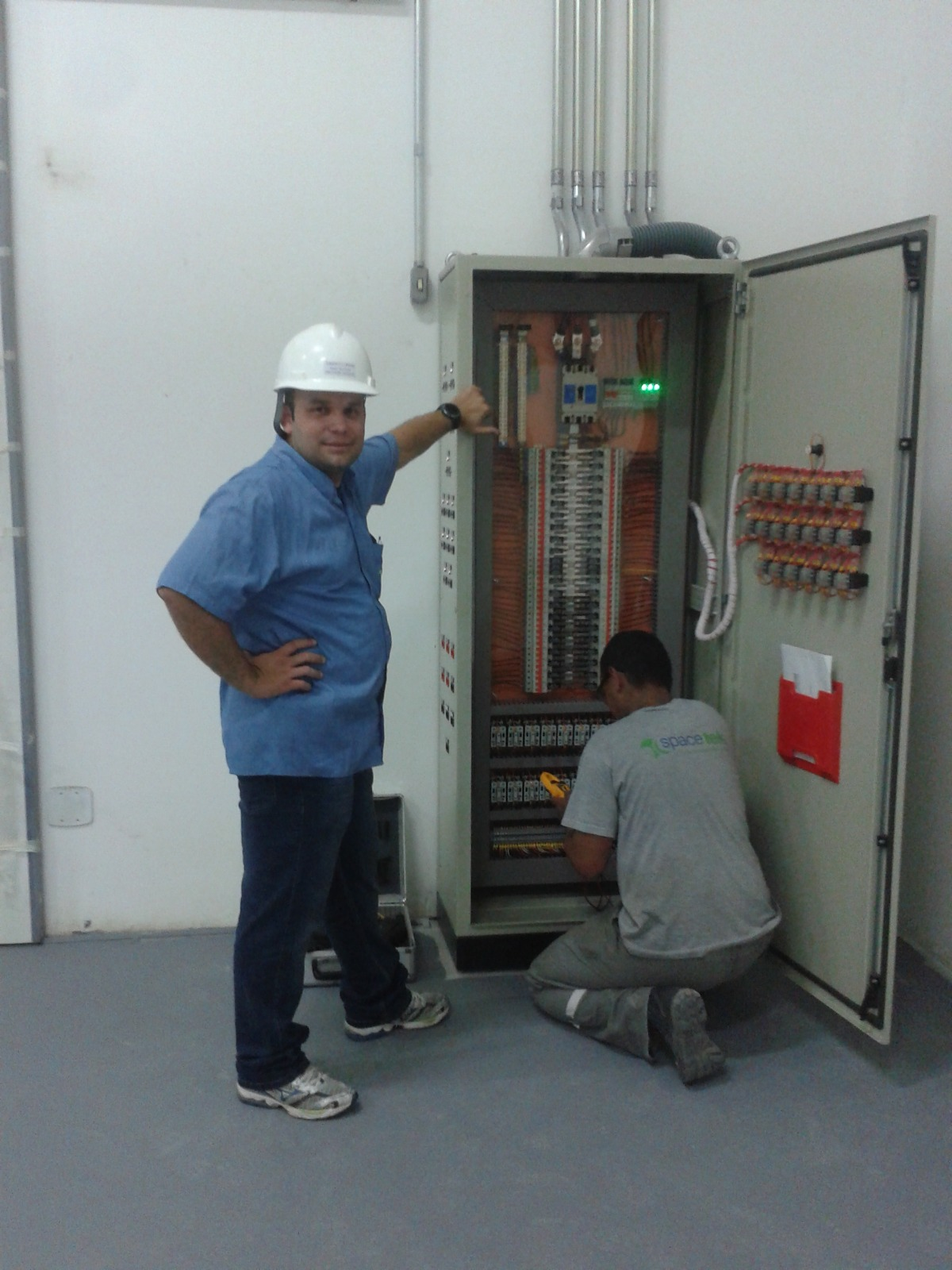 Equipe Spacetek trabalhando em um quadro elétrico durante a primeira fase da trajetória da empresa
